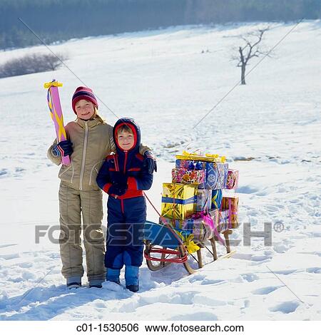 Children with Christmas presents on sledge in snow View Large Photo Image Stock Photograph - Children with Christmas presents on sledge in snow. Fotosearch