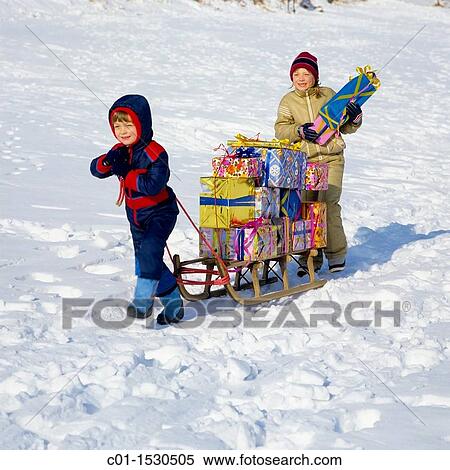 Children with Christmas presents on sledge in snow View Large Photo Image Stock Photography - Children with Christmas presents on sledge in snow. Fotosearch