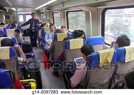 Stock Image - China, Beijing, Airport Express Train, public transportation, Beijing Capital International Airport, PEK, onboard, cabin, passengers, riders, Asian, man, luggage,.. Fotosearch