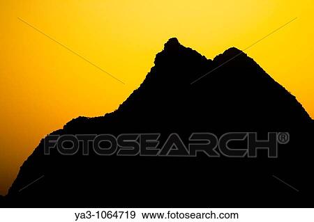 Stock Photo - China, Guangxi Zhuang Autonomous Region, Yangshuo County Sunset behind a karst peak near the town of Yangshuo. Fotosearch