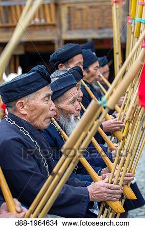 Picture - China, Guizhou province, Langde village, Long Skirt Miao people in traditional dress, mens are playing lusheng.. Fotosearch