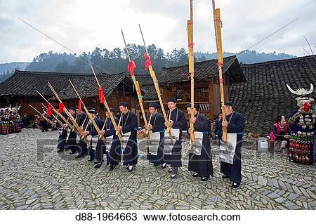 Stock Image - China, Guizhou province, Langde village, Long Skirt Miao people in traditional dress, mens are playing lusheng.. Fotosearch