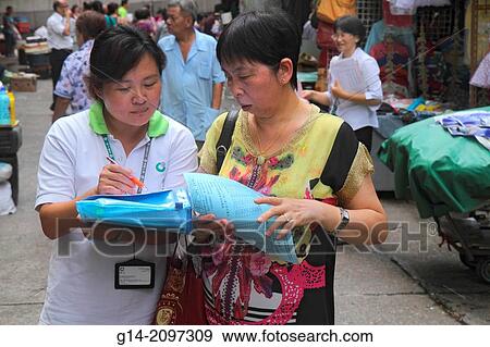 Stock Photo - China, Hong Kong, Island, North Point, Marble Street Market, shopping, Asian, woman, taking survey, offering life insurance plan, promotion, selling,.. Fotosearch