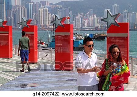 China, Hong Kong, Kowloon, Tsim Sha Tsui, Avenue of the Stars, Victoria Harbour, harbor, waterfront promenade, Asian, woman, man, couple, Island, city skyline, skyscrapers, high rise buildings,. View Large Photo Image Stock Image - China, Hong Kong, Kowloon, Tsim Sha Tsui, Avenue of the Stars, Victoria Harbour, harbor, waterfront promenade, Asian, woman, man, couple, Island, city skyline, skyscrapers, high rise buildings,.. Fotosearch