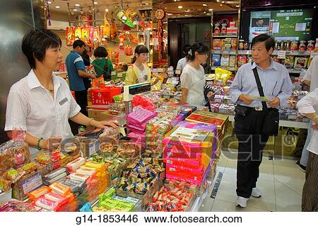 Stock Photograph - China, Shanghai, Huangpu District, East Nanjing Road, business, store, candy, sweets, treats, Asian, woman, clerk, job, employee, Chinese Mandarin symbols, hanzi, man, customer, display, for sale, shopping,. Fotosearch
