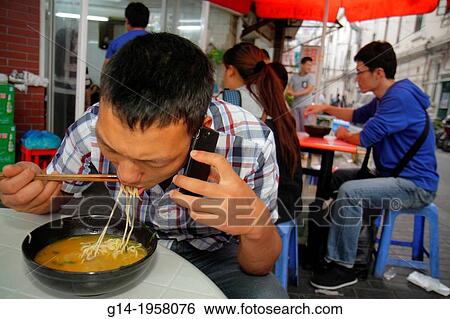 China, Shanghai, Huangpu District, Renmin Road, Yuyuan Garden, Asian, man, eating, chopsticks, noodle soup, smartphone, talking, cafe, restaurant,. View Large Photo Image Stock Photograph - China, Shanghai, Huangpu District, Renmin Road, Yuyuan Garden, Asian, man, eating, chopsticks, noodle soup, smartphone, talking, cafe, restaurant,.. Fotosearch