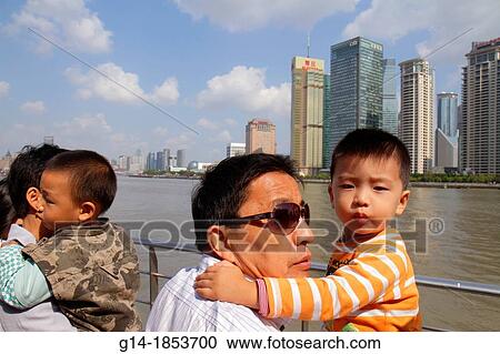 Stock Image - China, Shanghai, Huangpu River, Jinling East Road Dongchang Road Ferry, passengers, Asian, man, father, boy, son, holding, deck, Pudong Xin Qu District, Citigroup Tower, Aurora Plaza, waterfront,. Fotosearch