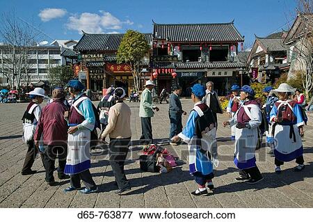 China, Yunnan Province, Lijiang, Lijiang Old Town, Women in Naxi Minority clothes dancing on Dong Dajie Street, the Naxi People are the main ethnic group in Lijiang View Large Photo Image Stock Photo - China, Yunnan Province, Lijiang, Lijiang Old Town, Women in Naxi Minority clothes dancing on Dong Dajie Street, the Naxi People are the main ethnic group in Lijiang. Fotosearch