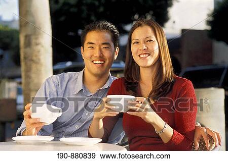 Stock Photo - Chinese American couple outdoor at coffee shop MR. Fotosearch