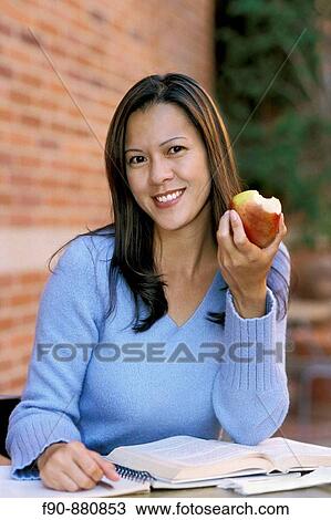 Chinese American woman at outdoor cafe eats apple MR View Large Photo Image Stock Image - Chinese American woman at outdoor cafe eats apple MR. Fotosearch