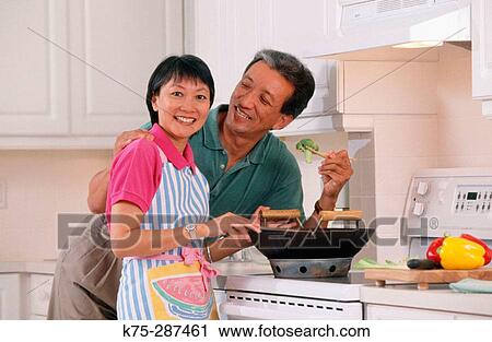 Stock Image - Chinese couple cooking Chinese food. Fotosearch