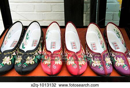 Stock Image - Chinese embroidered slippers for sale in Beijing China. Fotosearch
