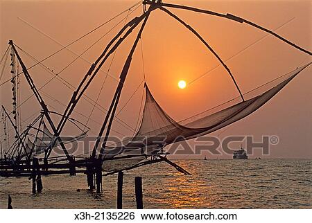 Stock Photograph - Chinese fishing nets at Kochi at sunset, State of Kerala, India, South Asia.. Fotosearch