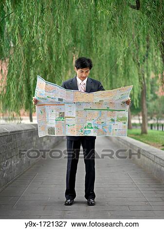 Chinese man looking at a map to help reorient or locate himself View Large Photo Image Stock Photo - Chinese man looking at a map to help reorient or locate himself. Fotosearch