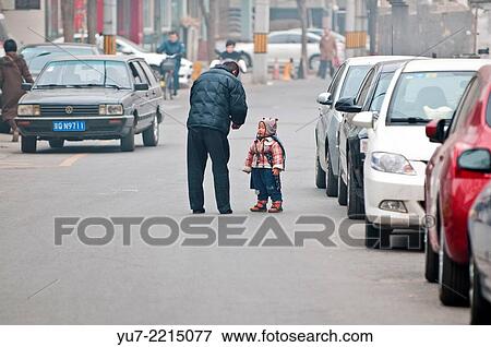 Chinese man with his daughter on street in Beijing, China. View Large Photo Image Stock Photo - Chinese man with his daughter on street in Beijing, China.. Fotosearch