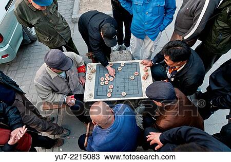 Chinese men playing Xiangqi also called Chinese chess in Beijing, China. View Large Photo Image Stock Image - Chinese men playing Xiangqi also called Chinese chess in Beijing, China.. Fotosearch