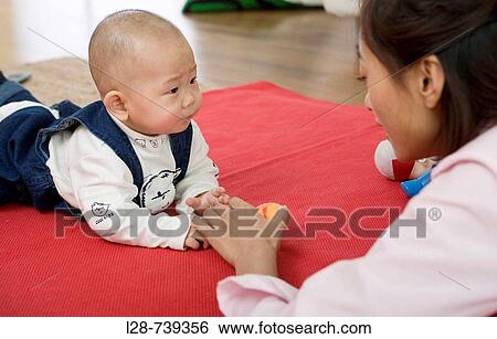 Stock Photograph - chinese mother and with baby at home. Fotosearch