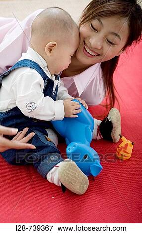 Stock Photo - Chinese mother plays with baby at home. Fotosearch