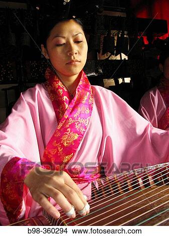 Chinese zither, musicians using traditional instruments to perform in Temple of Eternal Peace, Beihai Park (Beihai Gonggyuan). Beijing, China View Large Photo Image Picture - Chinese zither, musicians using traditional instruments to perform in Temple of Eternal Peace, Beihai Park (Beihai Gonggyuan). Beijing, China. Fotosearch