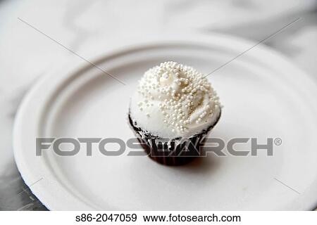 Chocolate Mini Cupcake, White Vanilla Icing, White Sugar Bead Sprinkles, on a White Plate. View Large Photo Image Stock Photo - Chocolate Mini Cupcake, White Vanilla Icing, White Sugar Bead Sprinkles, on a White Plate.. Fotosearch