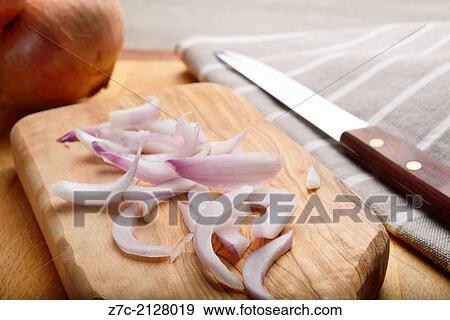 Stock Photo - Chopped onions on cutting board with a knife and linen clothe in the background set in a kitchen environment.. Fotosearch