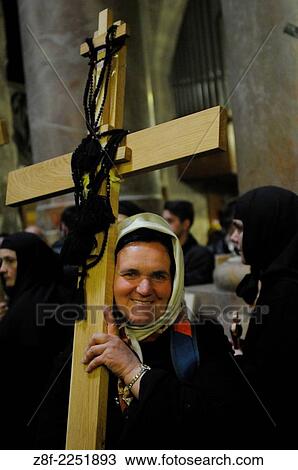 Stock Image - Christian worshippers holding a cross in the Church of the Holy Sepulchre during the Good Friday procession in Jerusalem's Old City.. Fotosearch