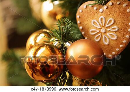 Stock Photograph - Christmas decoration Golden baubles and gingerbread on tree. Fotosearch