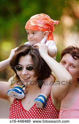 Chubby baby having fun riding on the shoulders of a young woman - Bucharest, Romania View Large Photo Image Stock Photo - Chubby baby having fun riding on the shoulders of a young woman - Bucharest, Romania. Fotosearch