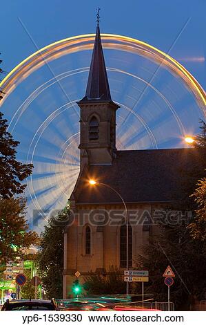 Stock Image - church and Ferris wheel at night, Luxembourg. Fotosearch