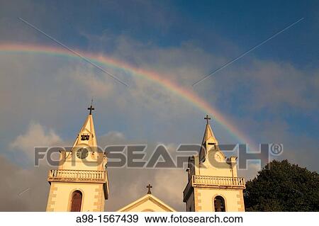 Church of Nossa Senhora das Neves and rainbow on sky after rainshower at Prazeres, Municipality of Calheta, Madeira, Portugal, Europe. View Large Photo Image Stock Photo - Church of Nossa Senhora das Neves and rainbow on sky after rainshower at Prazeres, Municipality of Calheta, Madeira, Portugal, Europe.. Fotosearch