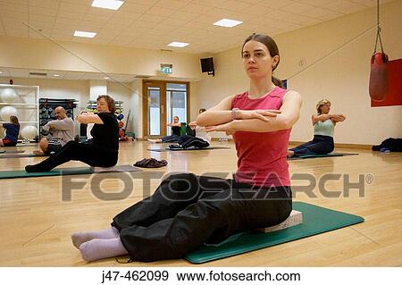 Class of people in pilates class exercising, arms crossed in front of them View Large Photo Image Stock Photo - Class of people in pilates class exercising, arms crossed in front of them. Fotosearch