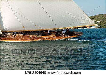 Classic sailboat in a regatta with sailors in the background at the Port Mahon, Mediterranean sea, Menorca, Balearic Islands, Spain. View Large Photo Image Stock Image - Classic sailboat in a regatta with sailors in the background at the Port Mahon, Mediterranean sea, Menorca, Balearic Islands, Spain.. Fotosearch