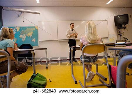 Stock Image - Classroom with students and teacher. Fotosearch