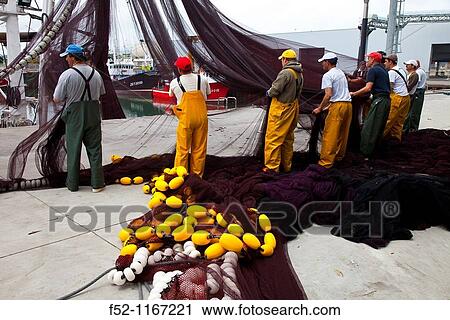 Stock Image - Cleaning fishing nets, Santoa Port, Cantabrian Sea, Cantabria, Spain. Fotosearch