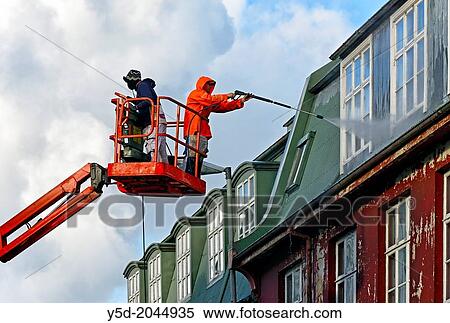 Stock Photography - cleaning windows in Reykjavik, in Iceland most windows don't have the possibility of opening, all works like cleaning or paiting or repairing must be done from the outside.. Fotosearch