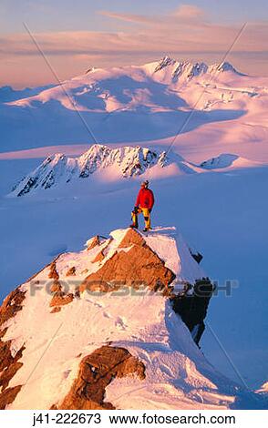 Stock Image - Climber on summit at sunset above Franz Josef Glacier. Westland National Park. New Zealand. Fotosearch