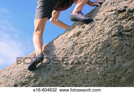 Stock Image - Climber reaching the top. Fotosearch