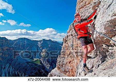 Stock Photo - climbing the Giovanni Lipella via ferrata on Tofana De Rozes in the Dolomite Mountains near the city of Cortina in northern Italy.. Fotosearch