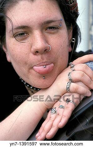 Close head shot of a teenage girl showing off her many studs and rings View Large Photo Image Stock Photo - Close head shot of a teenage girl showing off her many studs and rings. Fotosearch