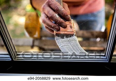 Close in detail of a 41 year old man painting the window trim of a house facing inside. View Large Photo Image Stock Photo - Close in detail of a 41 year old man painting the window trim of a house facing inside.. Fotosearch