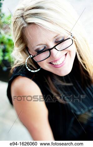Close in shot of a 31 year old blond woman wearing reading glasses with a flirty smile, eyes looking down View Large Photo Image Stock Image - Close in shot of a 31 year old blond woman wearing reading glasses with a flirty smile, eyes looking down. Fotosearch