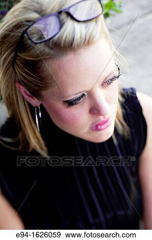 Stock Photo - Close in shot of a 31 year old blond woman wearing reading glasses eyes looking down. Fotosearch