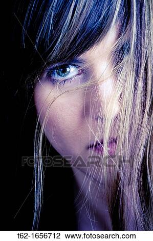 Stock Image - Close-looking woman with a straight face. Fotosearch