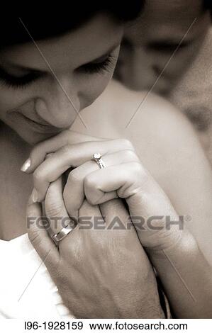 Stock Photo - close-up image of happy and content couple after wedding ceremony - now husband and wife - in a private moment - admiring their wedding rings. Fotosearch
