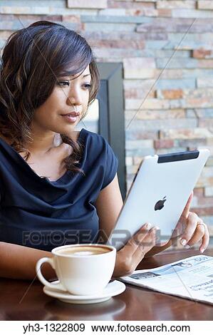 Close up of a African American young woman hand holding an iPad at a restaurant or cafe View Large Photo Image Stock Photo - Close up of a African American young woman hand holding an iPad at a restaurant or cafe. Fotosearch