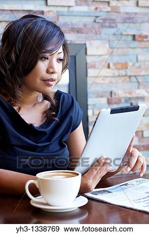 Close up of a African American young woman hand holding a digital tablet at a restaurant or cafe View Large Photo Image Stock Photo - Close up of a African American young woman hand holding a digital tablet at a restaurant or cafe. Fotosearch