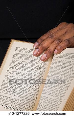Close-up of a black woman's hand holding a book View Large Photo Image Stock Photograph - Close-up of a black woman's hand holding a book. Fotosearch