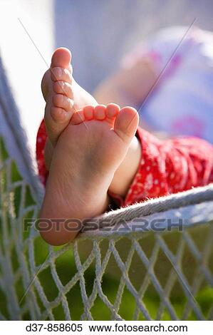 Stock Photography - Close up of a girl's feet resting on a hammock. Fotosearch