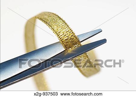 Close-up of a gold ribbon and scissor View Large Photo Image Stock Image - Close-up of a gold ribbon and scissor. Fotosearch