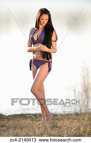 Close-up of a good looking young woman wearing a bikini on a beach at a sunny day in early spring. View Large Photo Image Stock Image - Close-up of a good looking young woman wearing a bikini on a beach at a sunny day in early spring.. Fotosearch